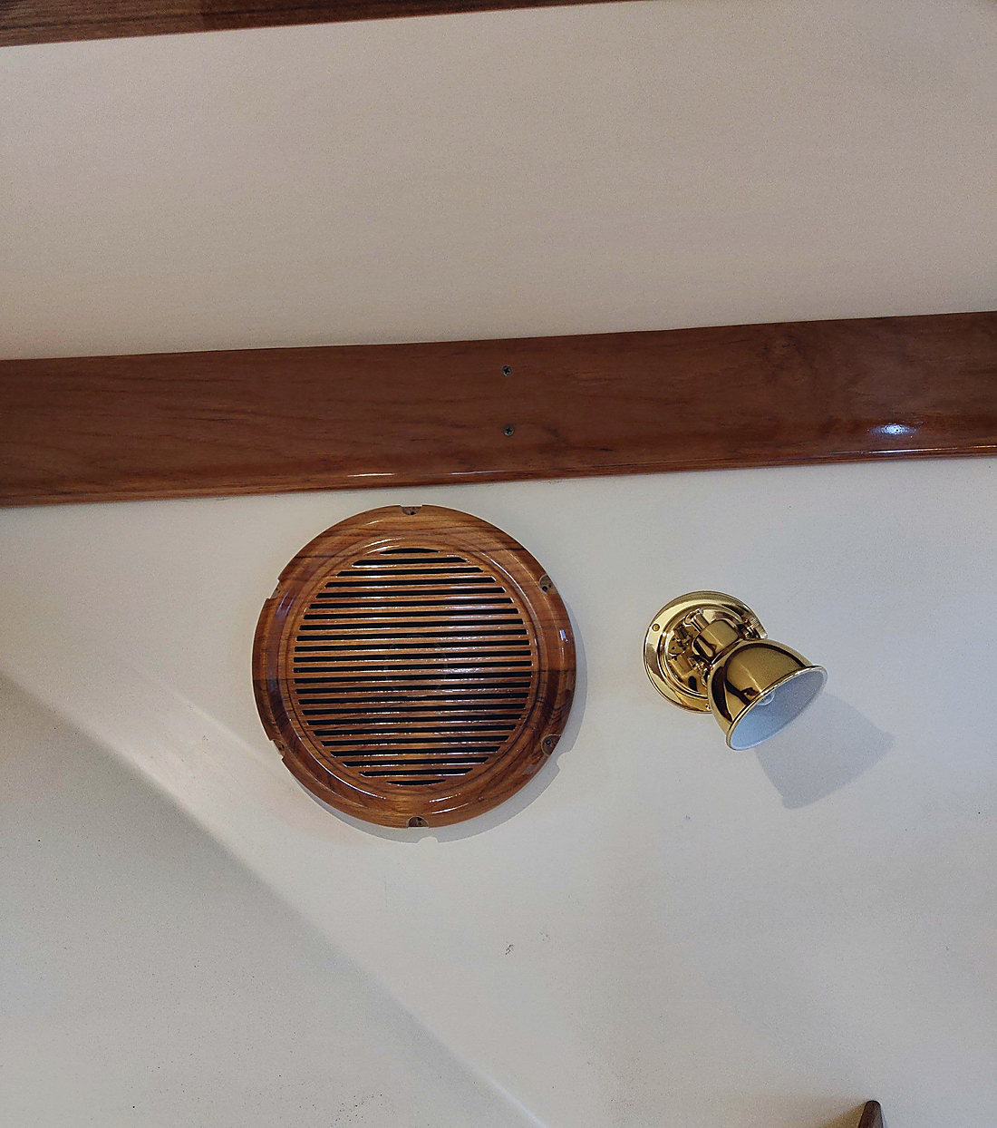 A speaker set into a teak bulkhead