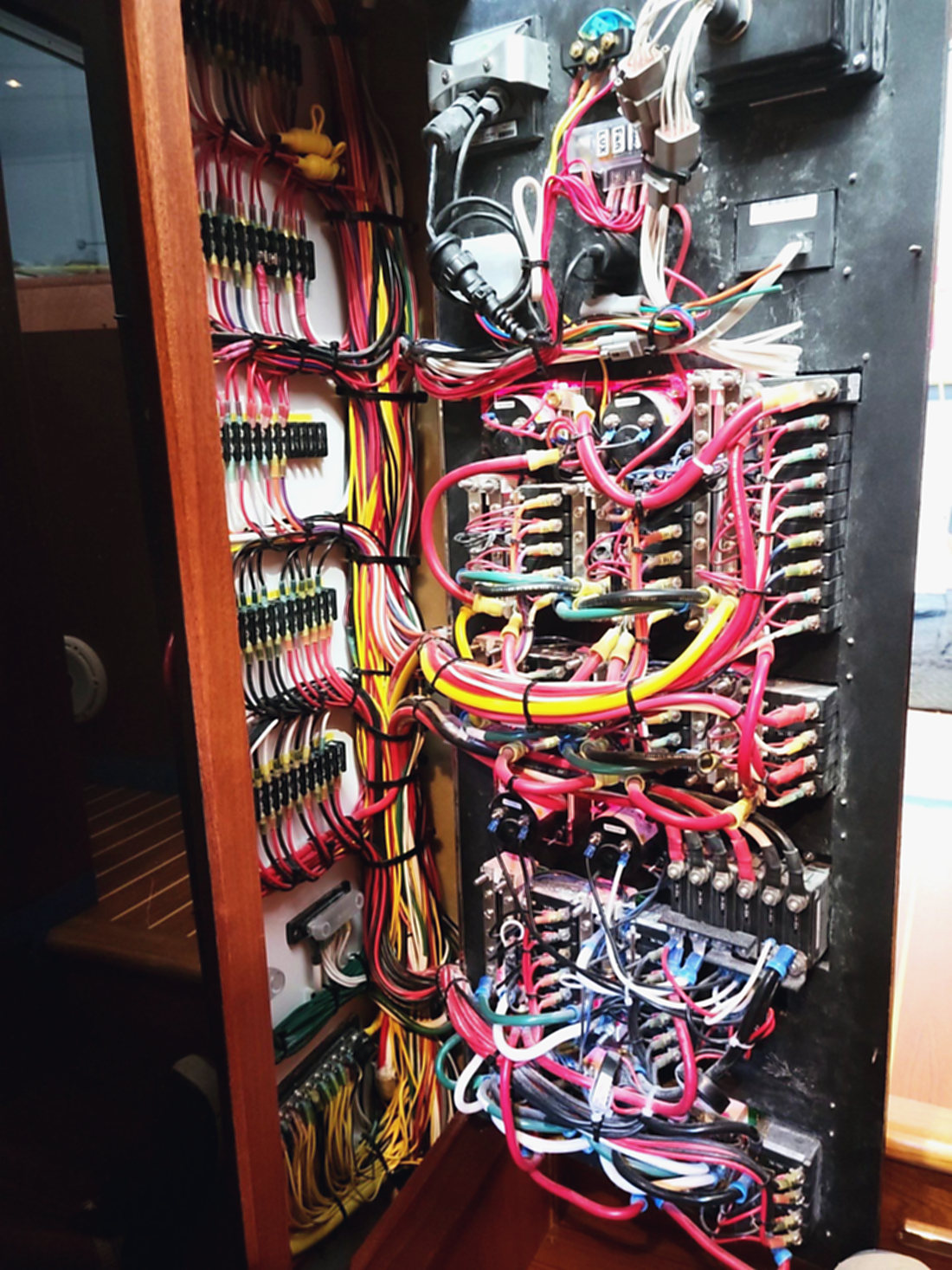 Behind the panel: a rewired breaker panel, the wiring loomed and run clean